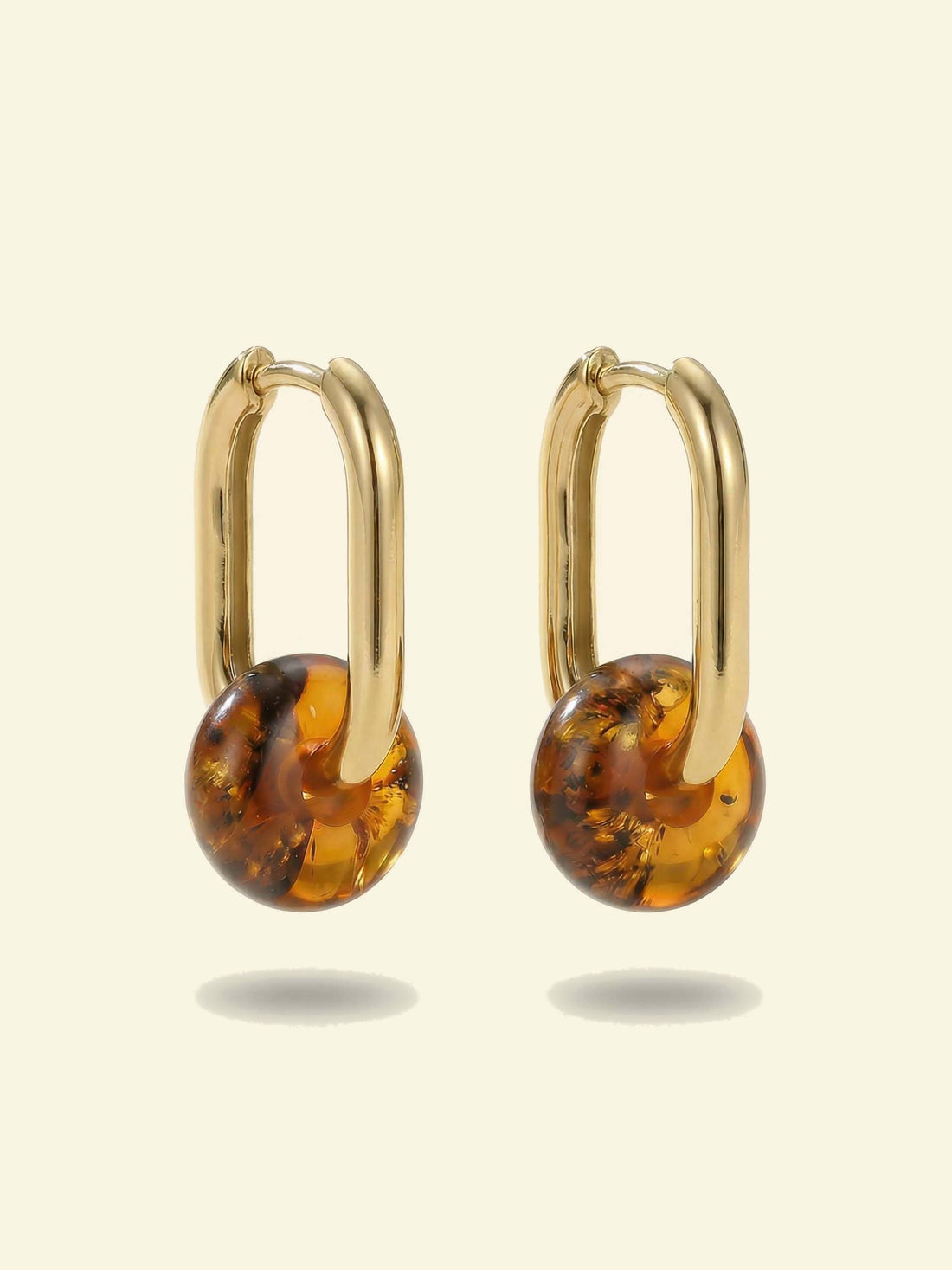 Dune Amber Hoops, pair of gold-tone oval hoops each with a round amber-coloured bead, front view