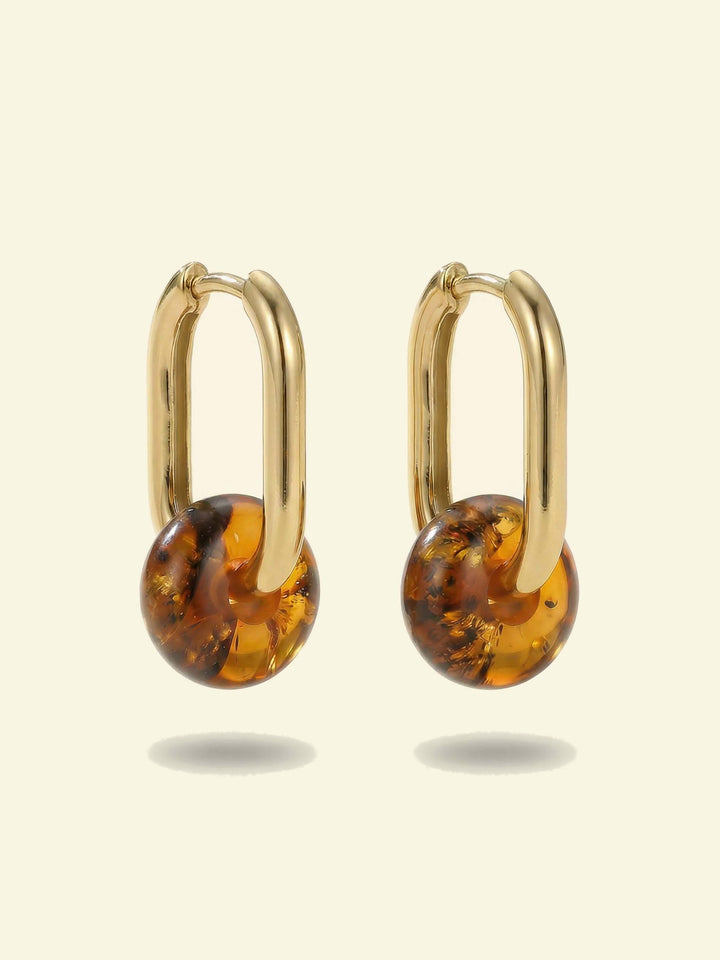 Dune Amber Hoops, pair of gold-tone oval hoops each with a round amber-coloured bead, front view