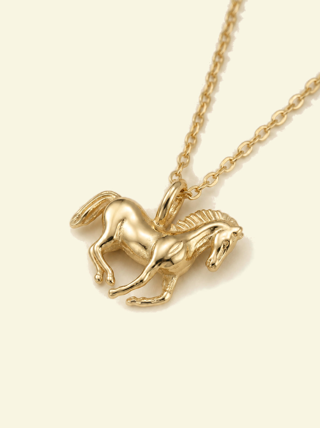 Stallion Pendant, close-up of the gold-tone horse pendant at an angle showing the mane, bail and chain