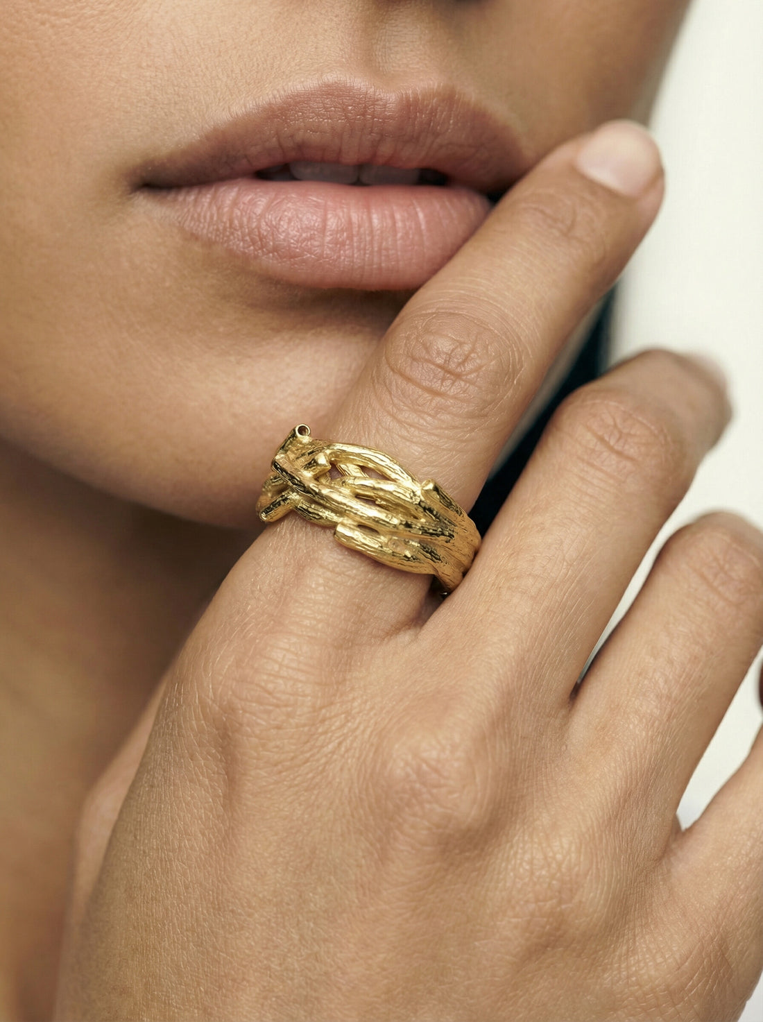 Oak Ring, gold-tone twig-textured ring worn on a woman's finger, hand held near her face