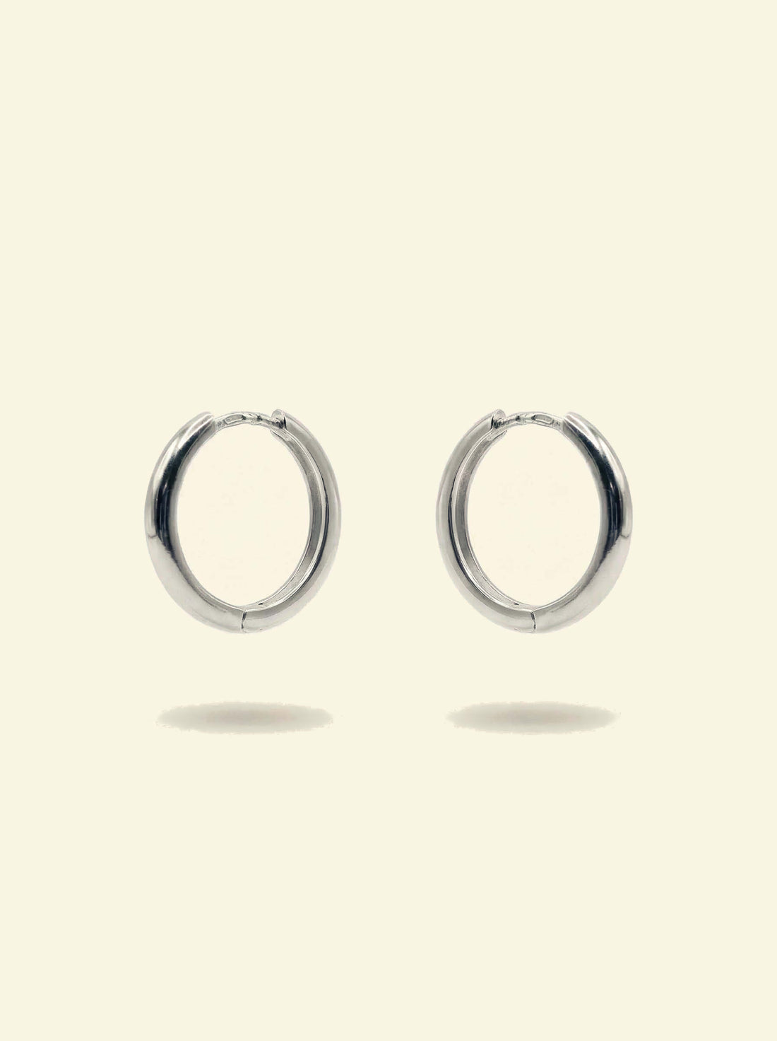 Classic Hoops, pair of smooth silver-tone hoops angled to the side with the hinge at the top