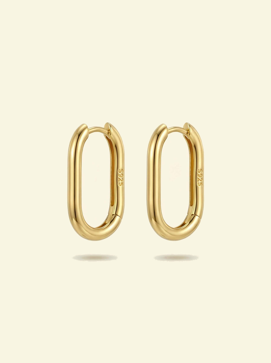 Link Large Ovals, pair of gold-tone oval hoop earrings with S925 stamp, front view on a cream background