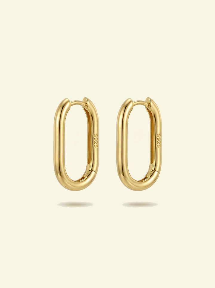 Link Large Ovals, pair of gold-tone oval hoop earrings with S925 stamp, front view on a cream background