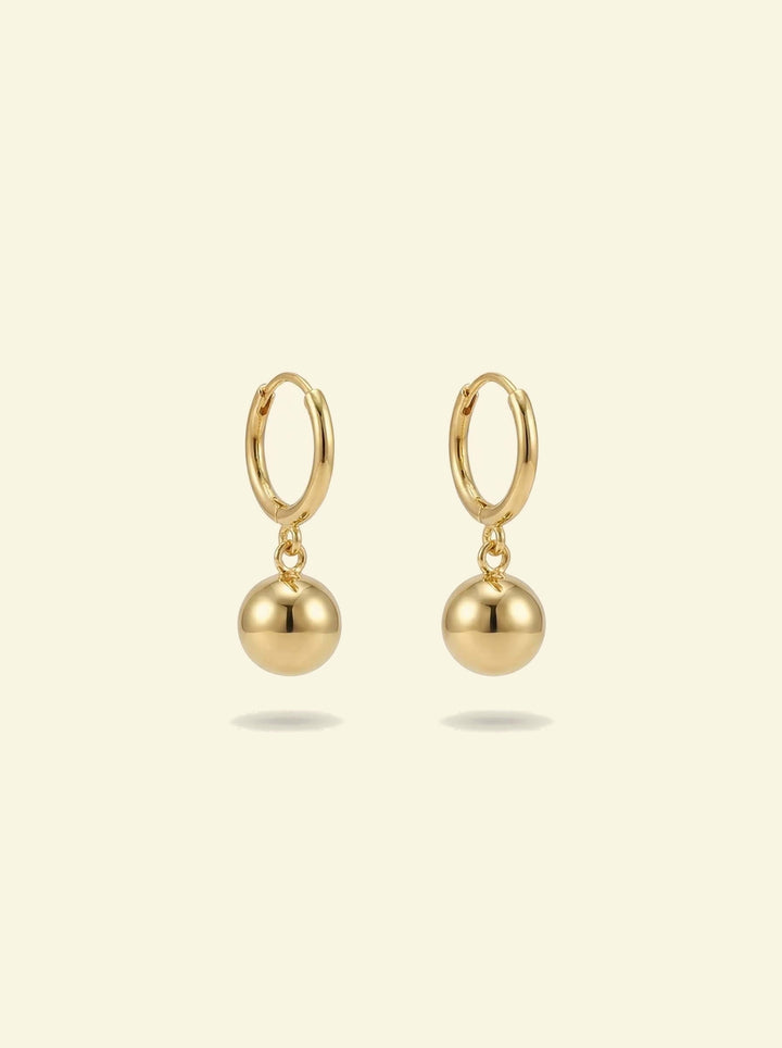 Dawn Drops, pair of small gold-tone huggie hoops with polished ball drops, front view