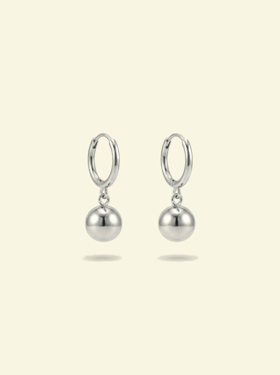 Dawn Drops, pair of small silver-tone huggie hoops with polished ball drops, front view
