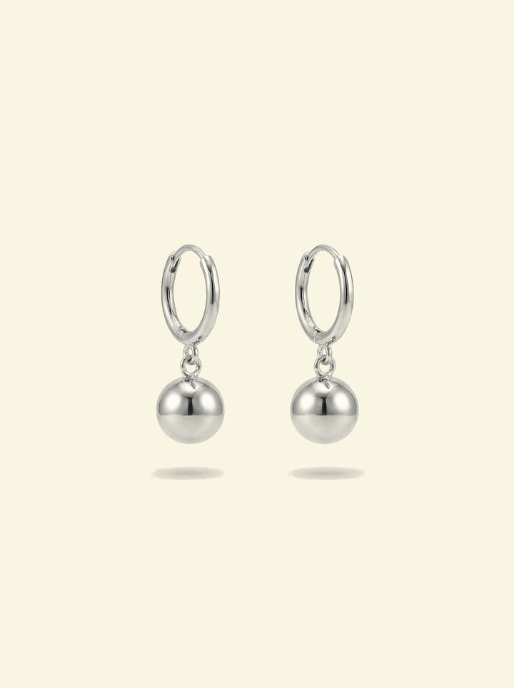 Dawn Drops, pair of small silver-tone huggie hoops with polished ball drops, front view