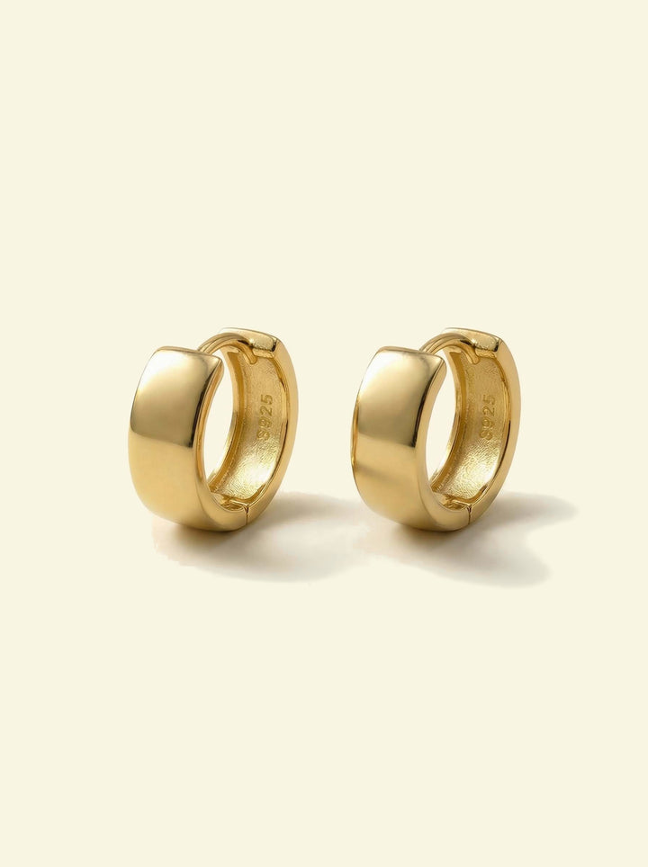 Forge Hoops, pair of wide gold-tone huggie hoops, front 3/4 view with S925 stamp inside