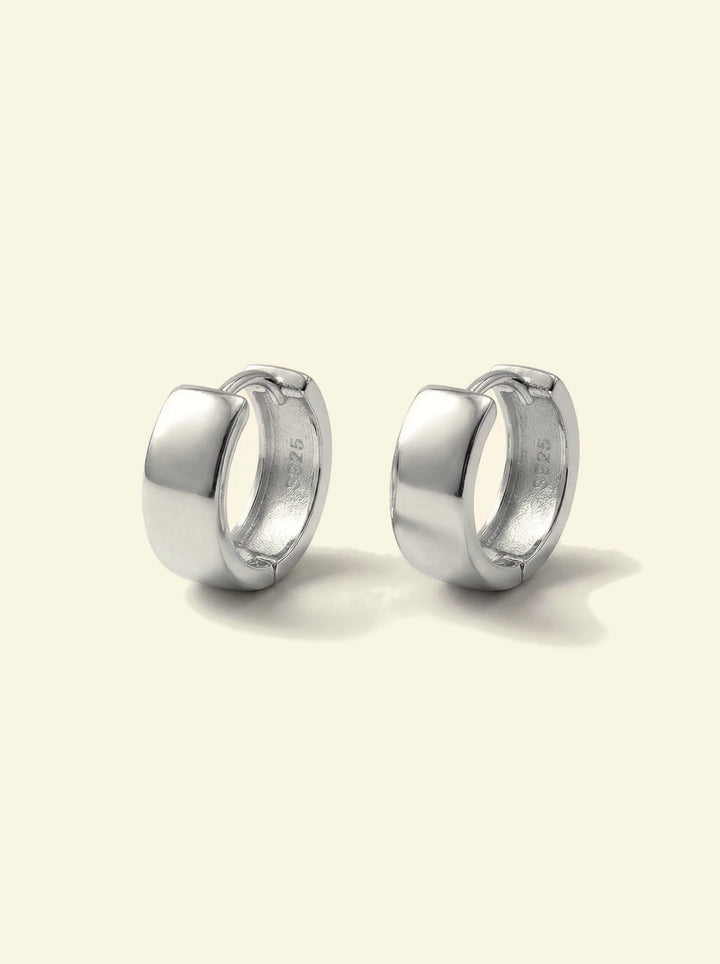 Forge Hoops, pair of silver-tone wide huggie hoops, front 3/4 view with S925 stamp inside