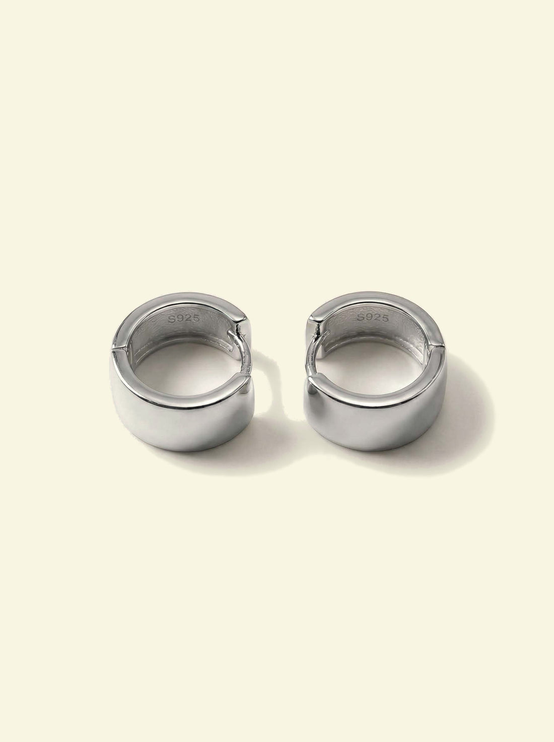 Forge Hoops, pair of silver-tone hoops lying flat with the S925 stamp visible inside the band