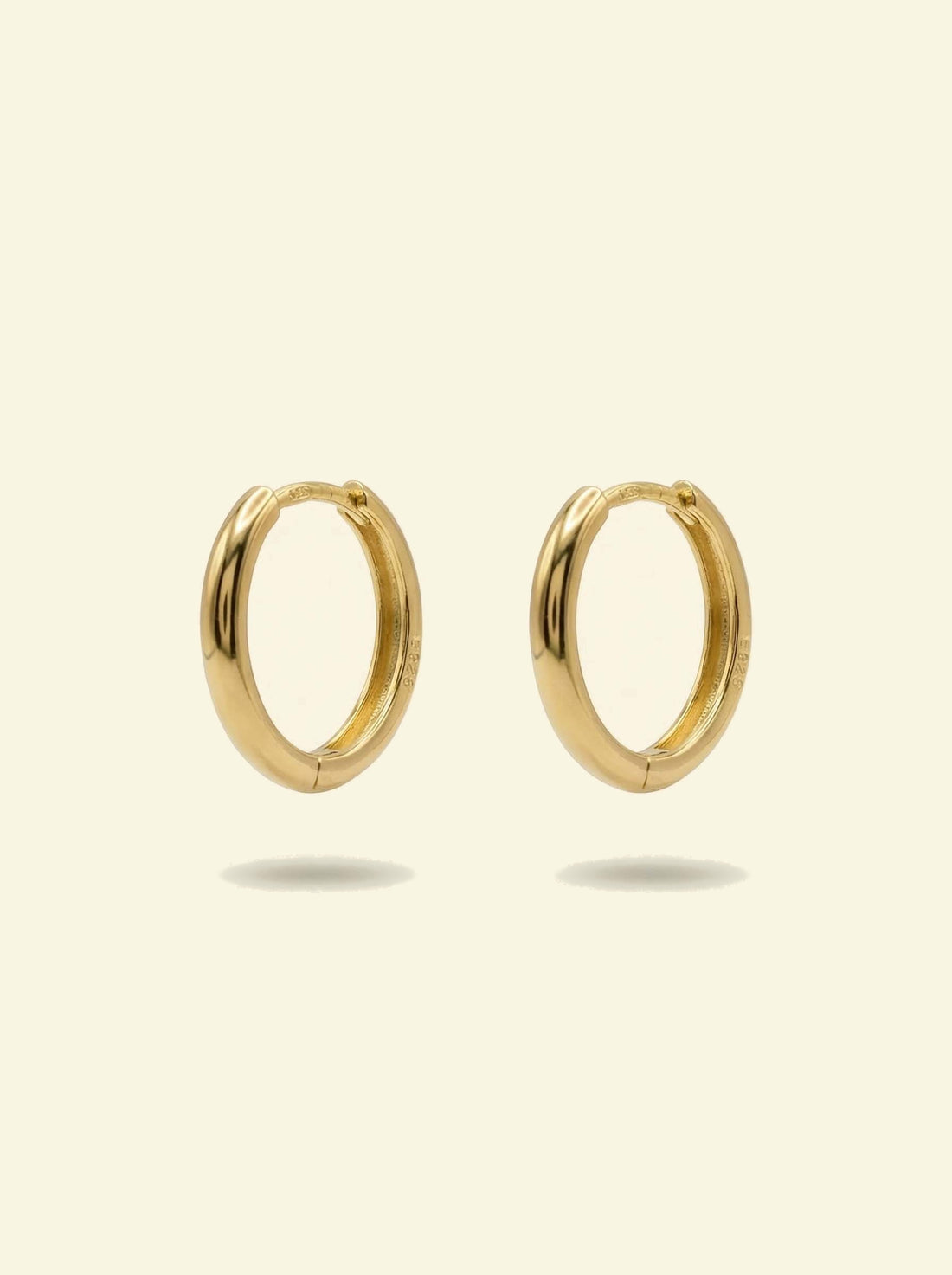 Classic Hoops, pair of smooth gold-tone huggie hoops standing upright, front 3/4 view