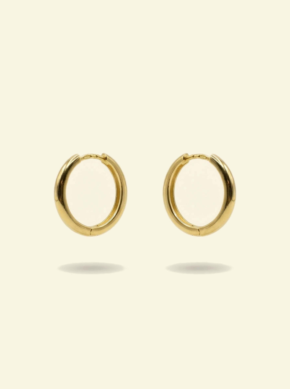 Classic Hoops, pair of smooth gold-tone hoops angled to the side with the hinge at the top