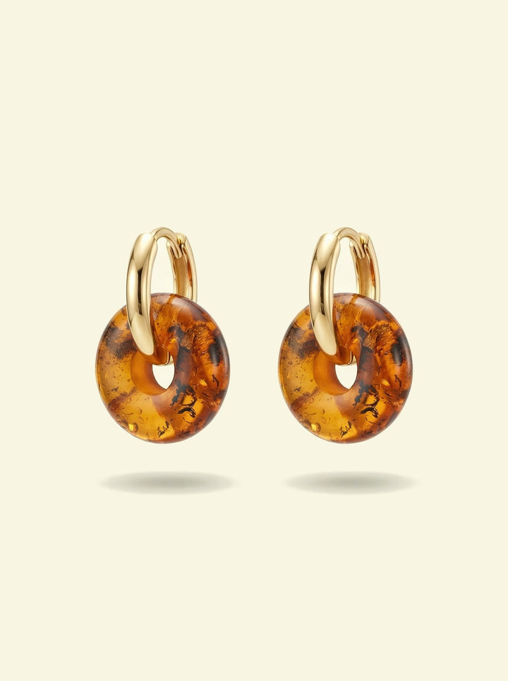 Nida Amber Hoops, pair of gold-tone huggie hoops with amber-coloured donut discs, hoops seen from the side