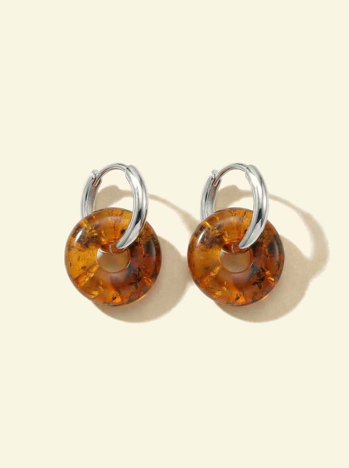 Nida Amber Hoops, pair of silver-tone hoops with amber-coloured discs, flat view with long soft shadows