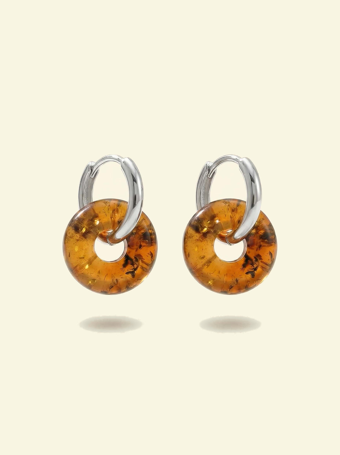 Nida Amber Hoops, pair of silver-tone huggie hoops with amber-coloured donut discs, front view