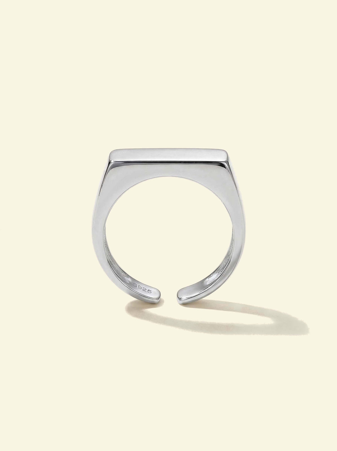 Preila Ring, silver-tone open band with a flat top, upright front view with a long shadow