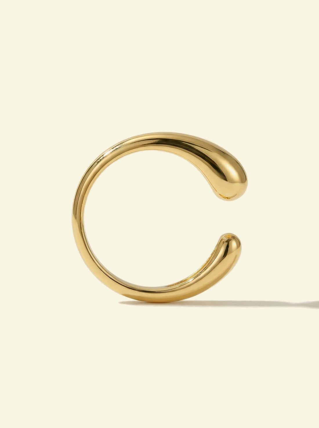 Sap Ring, gold-tone open ring standing upright, side view of the gap between the rounded ends