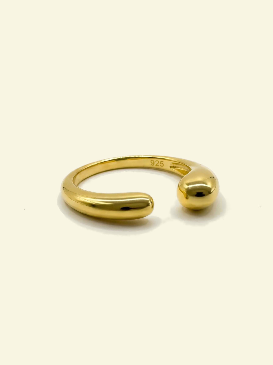 Sap Ring, gold-tone open ring lying down with the 925 stamp visible inside the band
