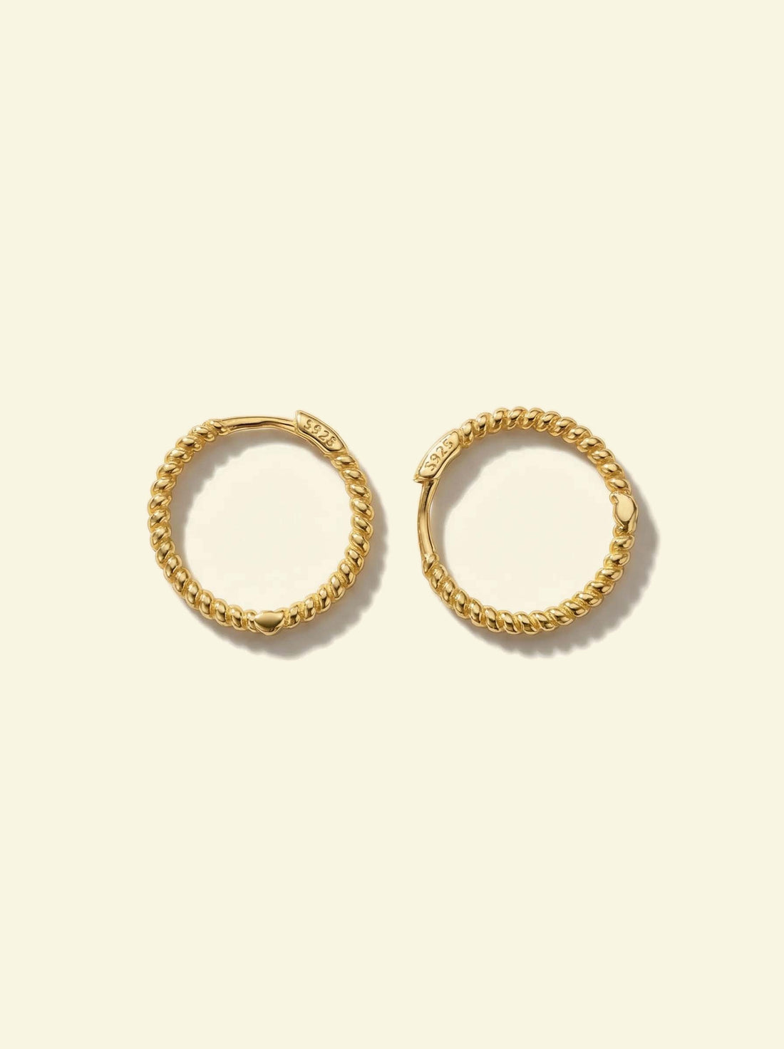 Sol Hoops, pair of gold-tone twisted rope hoops lying flat, one turned to show the S925 clasp
