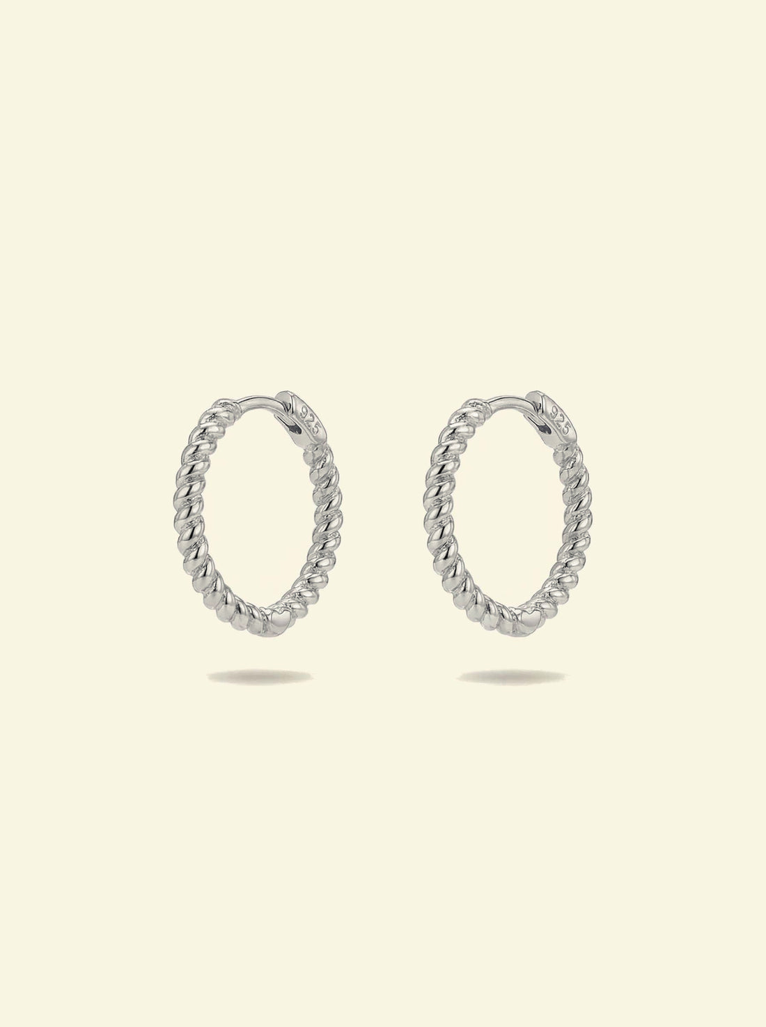 Sol Hoops, pair of silver-tone twisted rope hoops standing upright, front 3/4 view