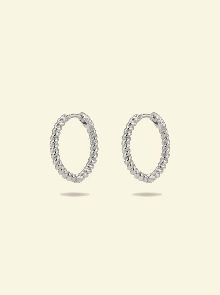 Sol Hoops, pair of silver-tone twisted rope hoops standing upright, front 3/4 view