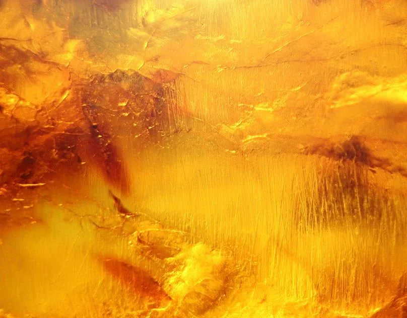 Macro close-up of golden Baltic amber with swirling honey and orange tones