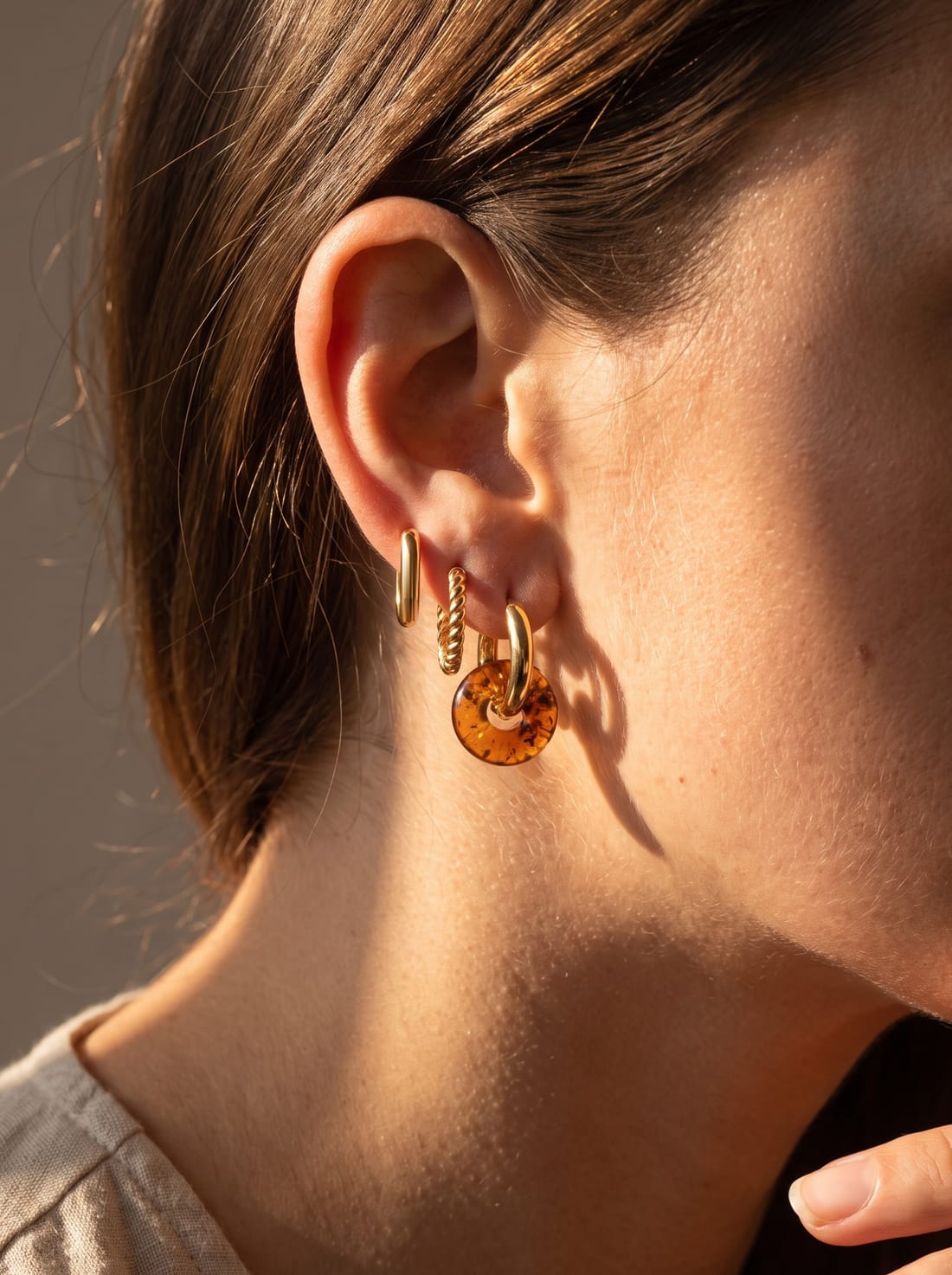 Look styled with Nida Amber Hoops, Link Mini Ovals and Sol Hoops (14K gold)